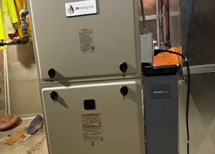 Residential furnace/air handler in a basement utility room, with ductwork and wiring nearby